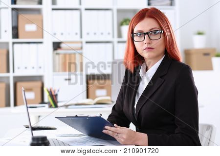 Businesswoman in the workplace in the office portrait in a simple suit smiles and looks at the camera creates an appearance of work and success causes confidence.