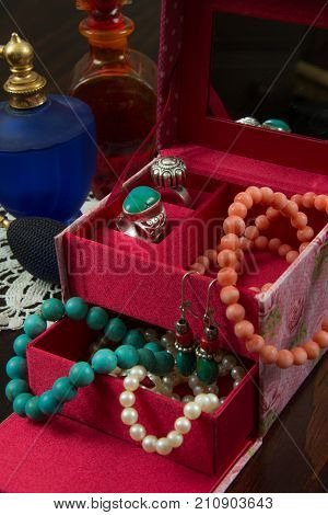 Closeup of a Jewels box with necklaces earrings bracelet rings and perfume bottles
