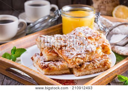 Grated pie with jam on a wooden table