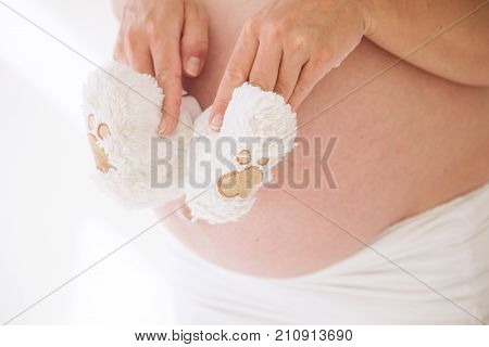 the stomach of a pregnant woman and baby stuff socks