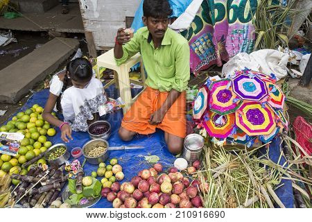 PONDICHERY PUDUCHERY INDIA - SEPTEMBER 09 2017. Unidentified man woman at his fruit and or vegetables shop in the main market of the city in south of India Asia.