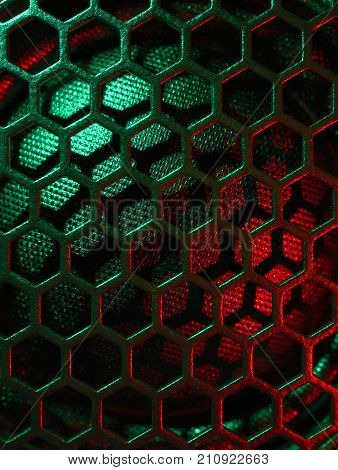 full frame colourful illuminated detail of a metallic grid in front of a loudspeaker