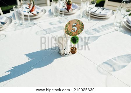 Round banquet table served to the wedding guests arrive. Solar flare on the tablecloth