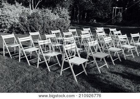 Place for wedding ceremony with white chairs and an arch of living plants