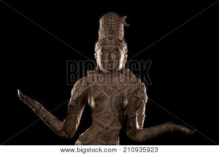 Lakshmi Hindu Goddess of wealth prosperity and fortune. Close up of traditional antique bronze statue isolated against black background.