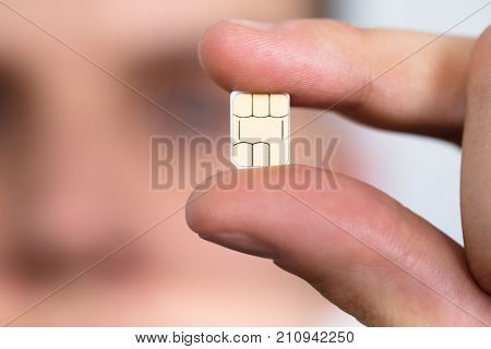 Close-up Of A Man Holding Nano Sim Card Between Fingers