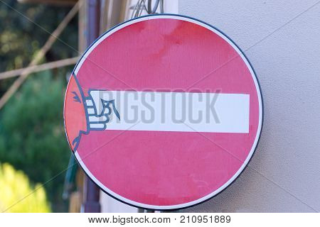 Road sign with an hand that break out the signal street art metropolitan art