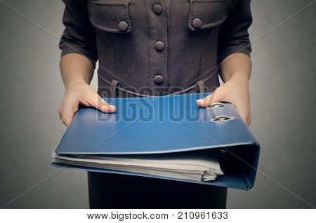 Business woman holding a stack of folders for documents in front of her close up. Overworked woman concept. Documents work. Secretary.