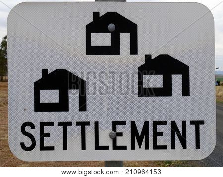 A sign in outback Australia advising of a settlement of homes along the road