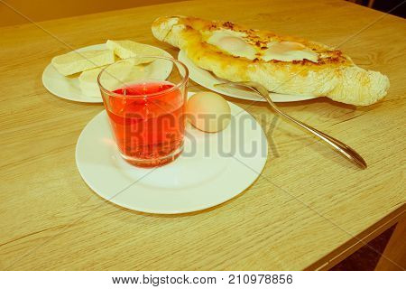 Adjarian khachapuri close-up. This traditional georgian dish contains brinsen cheese butter and row egg. Khachapuri on ajarski - recipe of Georgian cuisine - Retro color