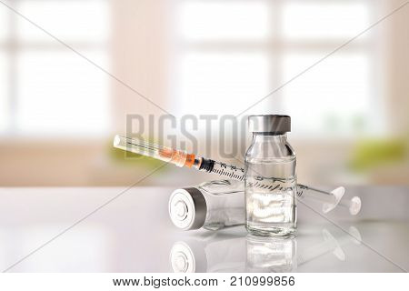 Vials And Syringe On White Table With Background Windows