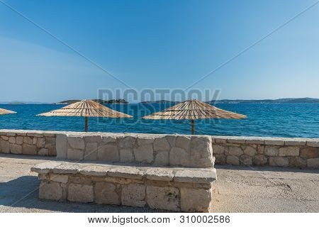 Beautiful Summer Seascape With Sun Umbrellas In Orebic, Peljesac Peninsula, Dalmatia, Croatia