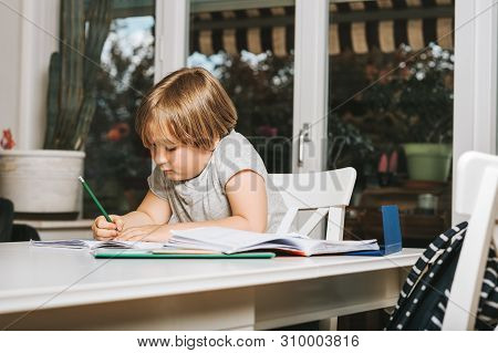Cute Little Boy Doing Homework For School, Writing In Excersice Notebook