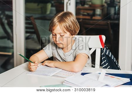 Cute Little Boy Doing Homework For School, Writing In Excersice Notebook