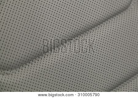 Part Of Leather Car Headrest Seat Details. Сlose-up Gray  Perforated Leather Car Seat. Skin Texture
