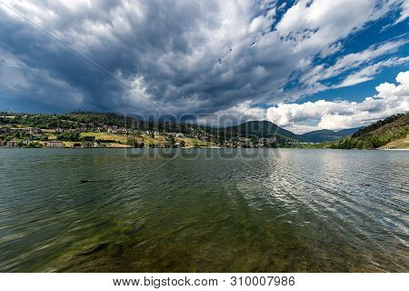 Serraia Lake (lago Della Serraia) With The Italian Alps And The Small Town Of Baselga Di Pine, Trent