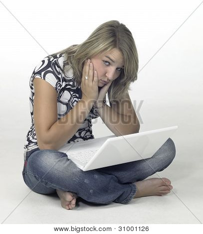 Verveeld meisje, zittend op de vloer met witte Laptop