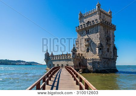 Scenic Belem Tower And Wooden Bridge Miroring With Low Tides On Tagus River. Torre De Belem Is Unesc