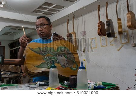 Gianyar,bali/indonesia-may 30 2019: The Guitar Craftsman Are Working On Painting Guitars In A Classi