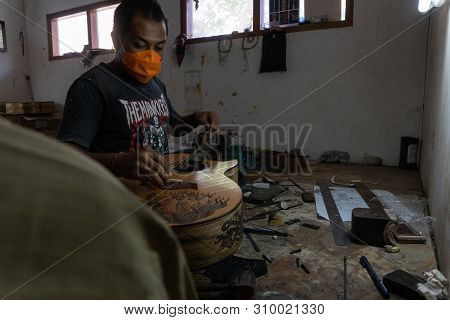 Gianyar,bali/indonesia-may 30 2019: A Classical Guitar Craftsman Is Pairing Guitar Strings To His Gu
