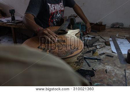 Gianyar,bali/indonesia-may 30 2019: A Classical Guitar Craftsman Is Pairing Guitar Strings To His Gu