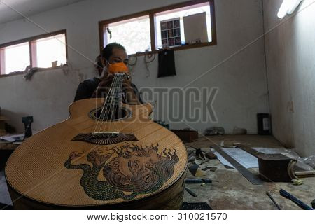 Gianyar,bali/indonesia-may 30 2019: A Classical Guitar Craftsman Is Pairing Guitar Strings To His Gu
