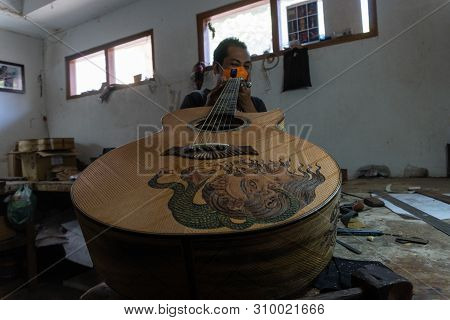 Gianyar,bali/indonesia-may 30 2019: A Classical Guitar Craftsman Is Pairing Guitar Strings To His Gu