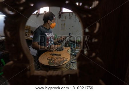 Gianyar,bali/indonesia-may 30 2019: A Classical Guitar Craftsman Is Pairing Guitar Strings To His Gu