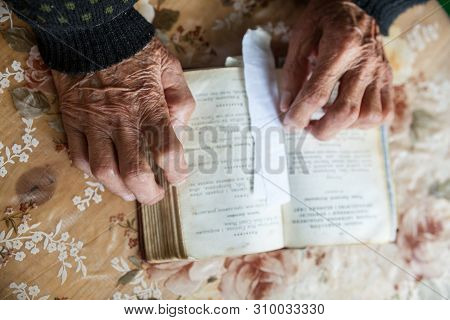 Old Woman Hands On The Open Prayer Book (christian Prayer Book In Ukrainian). Reading The Book. Pray