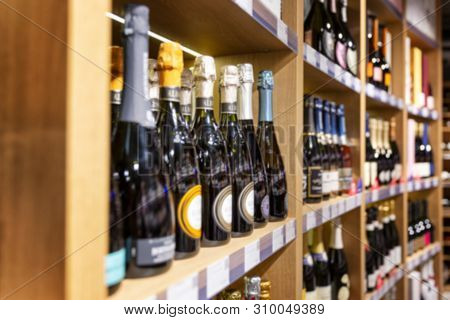 Large Wine Racks. Many Different Alcoholic Beverages. Luxury Enoteca. The Photo Is Blurry. Close-up.