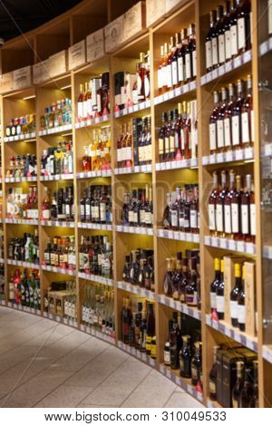 Large Wine Racks. Many Different Alcoholic Beverages. Luxury Enoteca. The Photo Is Blurry. Close-up.