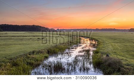 Sunset Landscape Of Lowland River Koningsdiep In The Netherlands