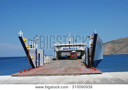 TILOS, GREECE - JUNE 12, 2019: Cargo ship Agios Antonios moored at Livadia harbour on the Greek island of Tilos. The 71.8mtr vessel was built in 1977 in Greece.