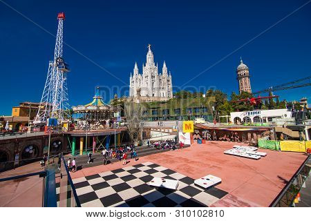 Barcelona, Spain - April, 2019: The Tibidabo Amusement Park On Mount Tibidabo On Background Of Blue