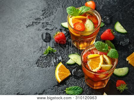 Refreshing Pimms Cocktail With Fruit And Vegetables On Rustic Black Table