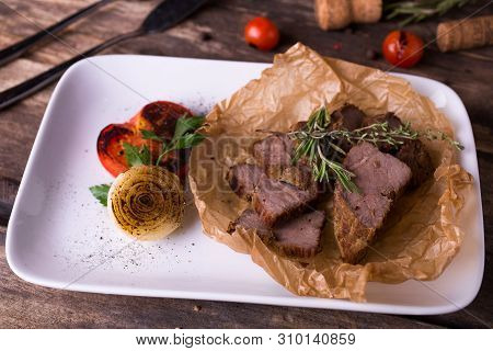 Baked Pork And Grilled Vegetables On White Plate