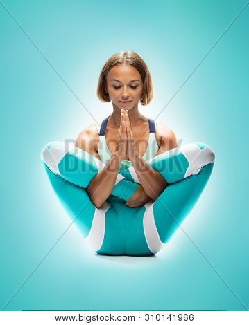 Athletic Young Woman Practicing Yoga On Turquoise Background.