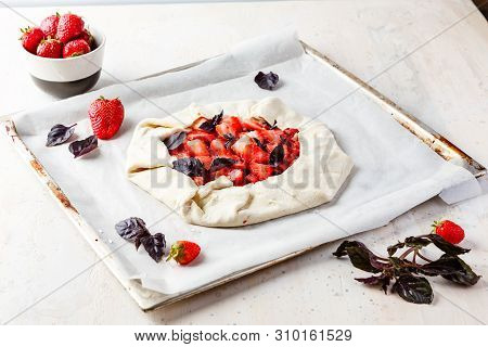 Homemade Strawberry Open Cake Of Gallet With Purple Basil And Balsamic Sauce Before Baking On A Ligh