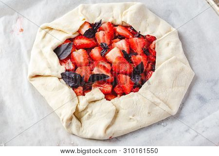Homemade Strawberry Open Cake Of Gallet With Purple Basil And Balsamic Sauce Before Baking On A Ligh