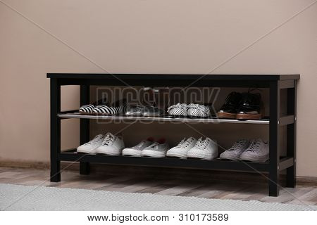 Shoe Rack With Different Footwear Near Color Wall. Stylish Hallway Interior