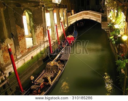 Canal In Venice At Night With Gondola Ant Bridge, Italy