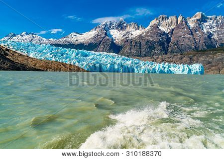 Natural Landscape At Glacier Grey With The Snowy Rock Mountain, Lake Grey And Water Splash Behind Th