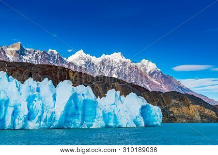 Blue Iceberg Of Grey Glacier, The Ripples Of Grey Lake And The Beautiful Mountain In Torres Del Pain