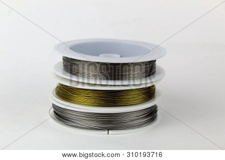 Colored Wire For Making Jewelry From Natural Stones And Natural Materials. Wire On White Plastic Coi