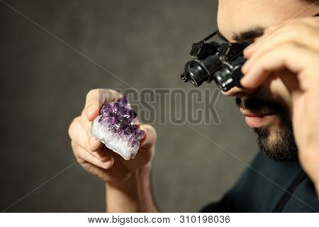 Male Jeweler Evaluating Semi Precious Gemstone In Workshop, Closeup