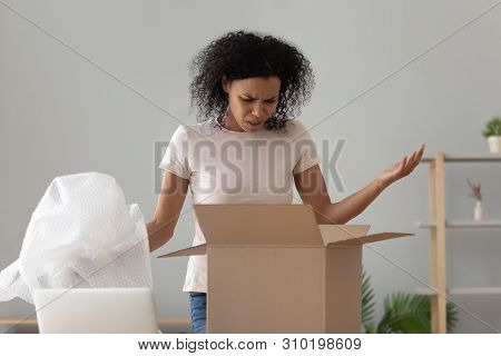 Disappointed Shocked African Woman Open Cardboard Box Receive Bad Parcel