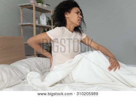 Young Black Woman Sit On Bed Touching Back Feel Backpain