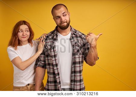 Angry Bearded Man Looks Strict And Dissatisfied, Points Away With Thumb, Demonstrates Something He D