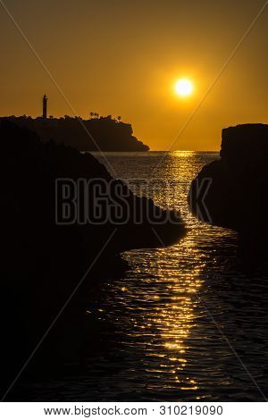 The Lighthouse And The Sea In Front Of Porto Colom At Sunrise