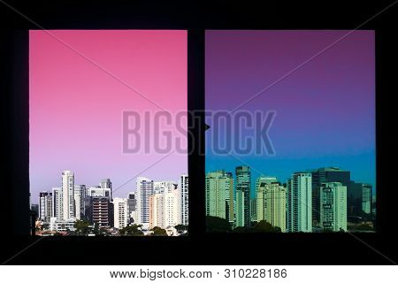 The View Of The Skyscraper Buildings Through The Window With A Pink Neon Sky. City Concept